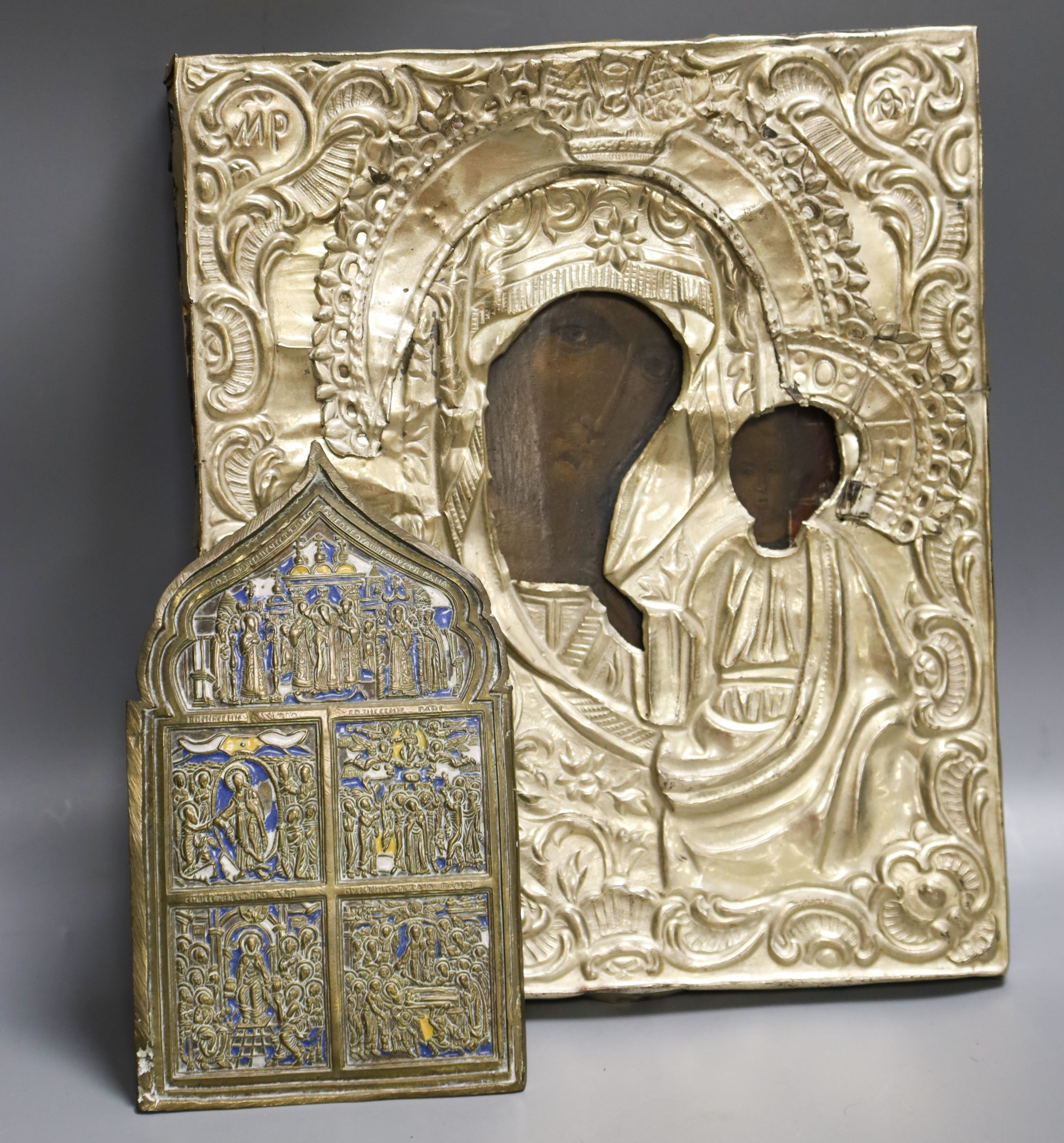 A Russian base metal oklad icon and a similar enamelled bronze panel, once part of a tryptich 27x23cm